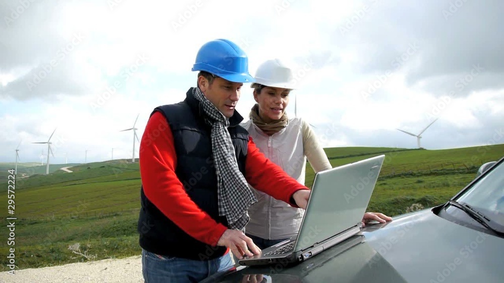 Engineers working by wind turbines field Engineers working by wind turbines field