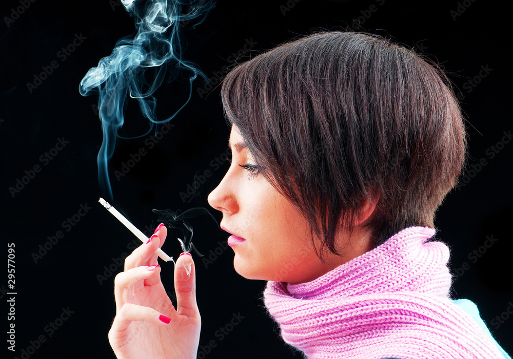 Fototapeta premium Young girl smoking on black