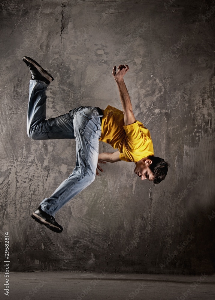 Young man jumping against grunge wall