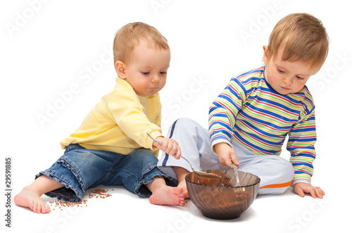 Two adorable children playing with buckwheat. Isolated on white