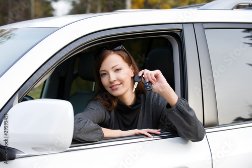 Successful woman with keys from car