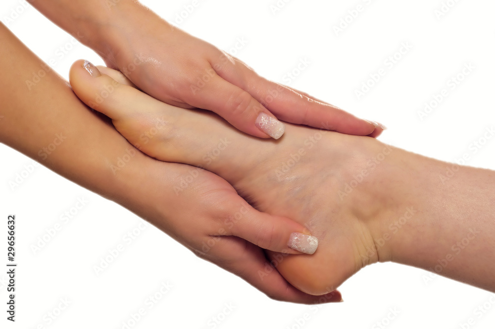 zwei Hände einer Therapeutin umschliessen Fuß einer Frau