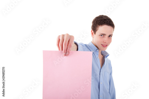 young smiling man holding a pink sheet of paper in his hand;