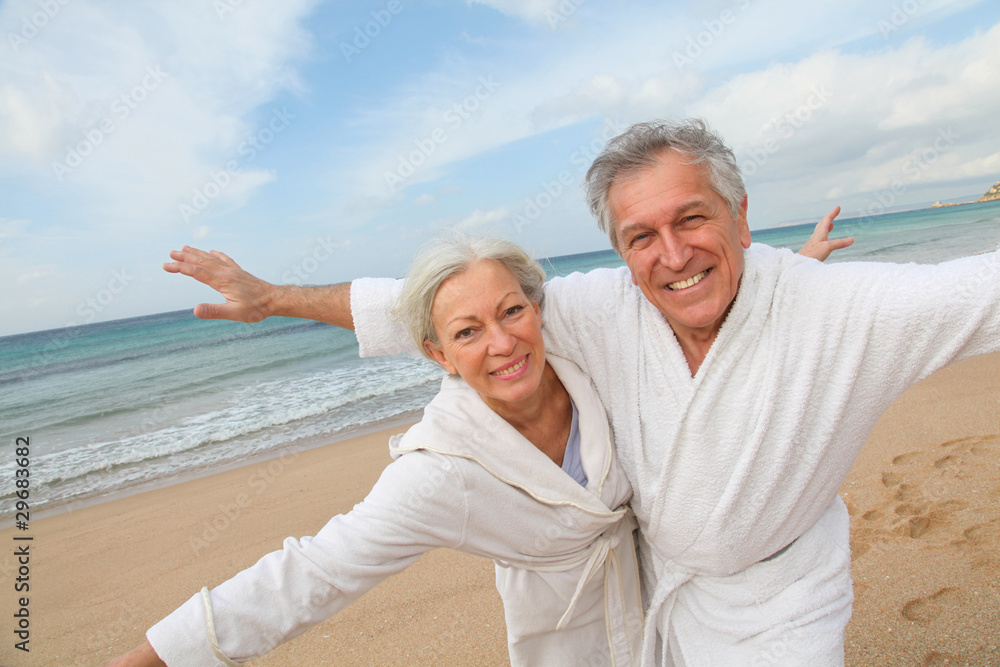 Senior couple in bathrobe at the beach