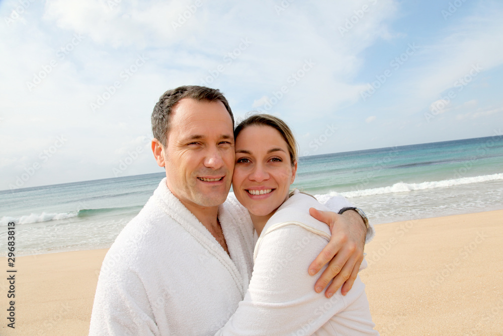 Couple relaxing in bathrobe at the beach Couple relaxing in bathrobe at the beach