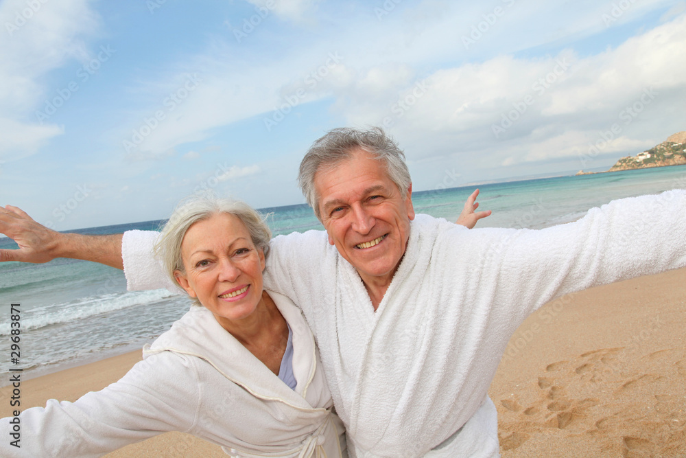 Senior couple in bathrobe at the beach