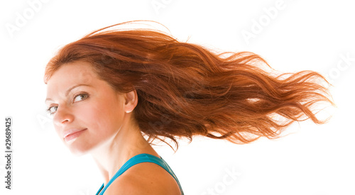 фотографія charming red-haired young fit woman with her hair flying