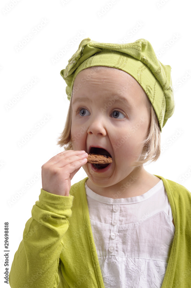 hungry little girl eating a cookie
