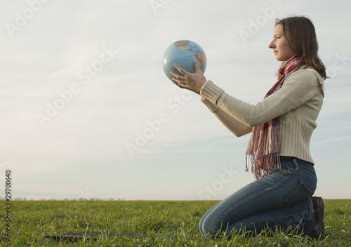 Obraz na płótnie Teen girl sitting with a globe on the grass w salonie