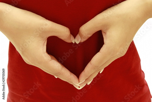 women's hands take love heart symbol on red t-shirt photo