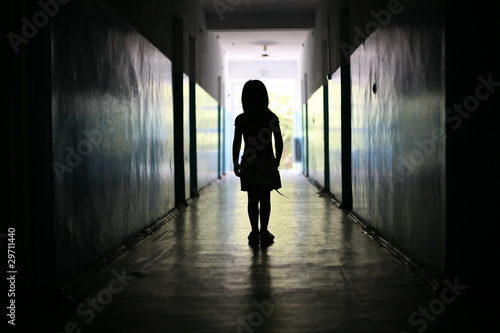 Silhouette of the little girl in a long corridor