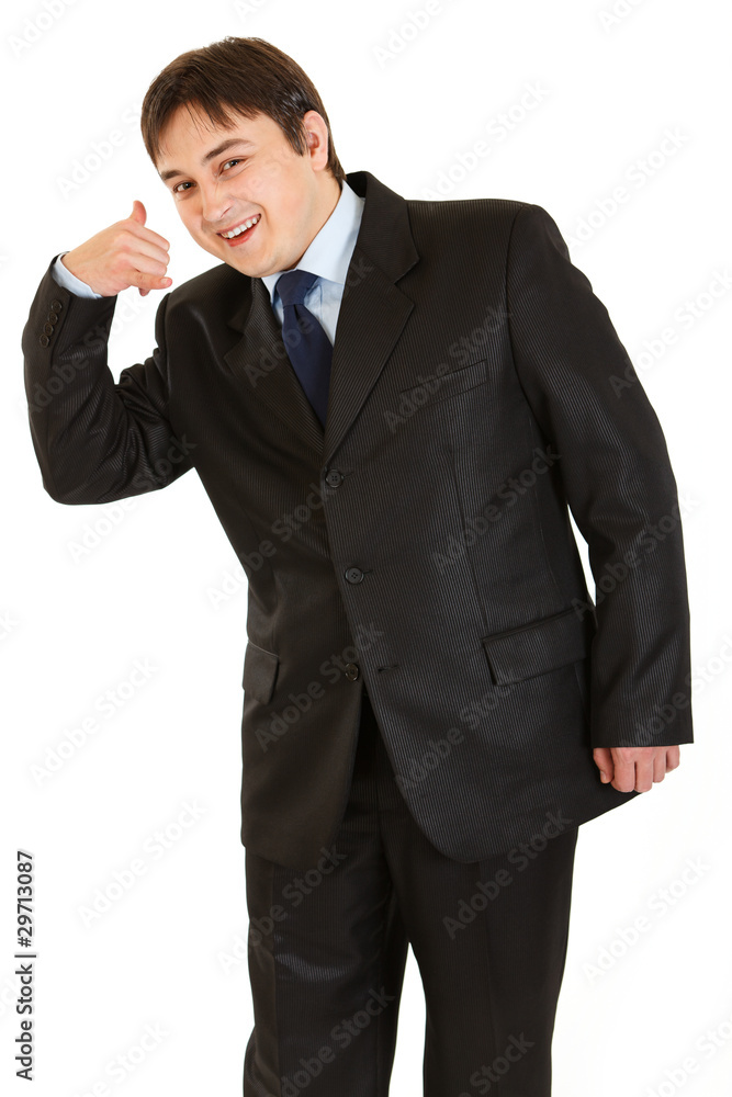 Smiling young businessman showing contact me gesture Smiling young businessman showing contact me gesture
