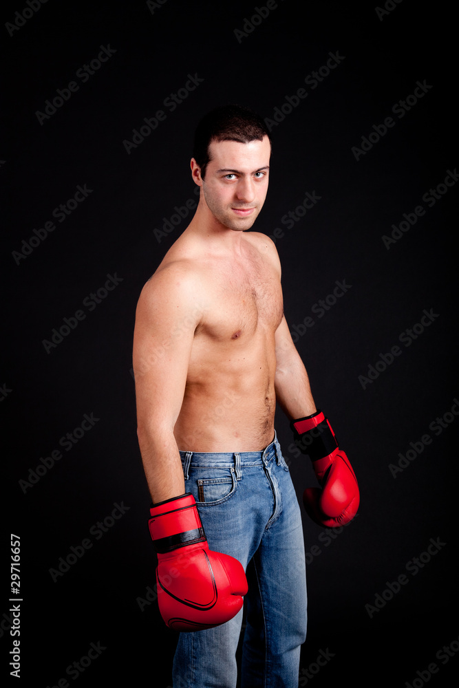 Young man with boxing gloves isolated on black