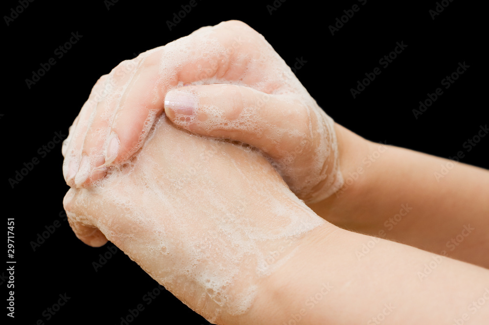 Female hands in soapsuds on black background