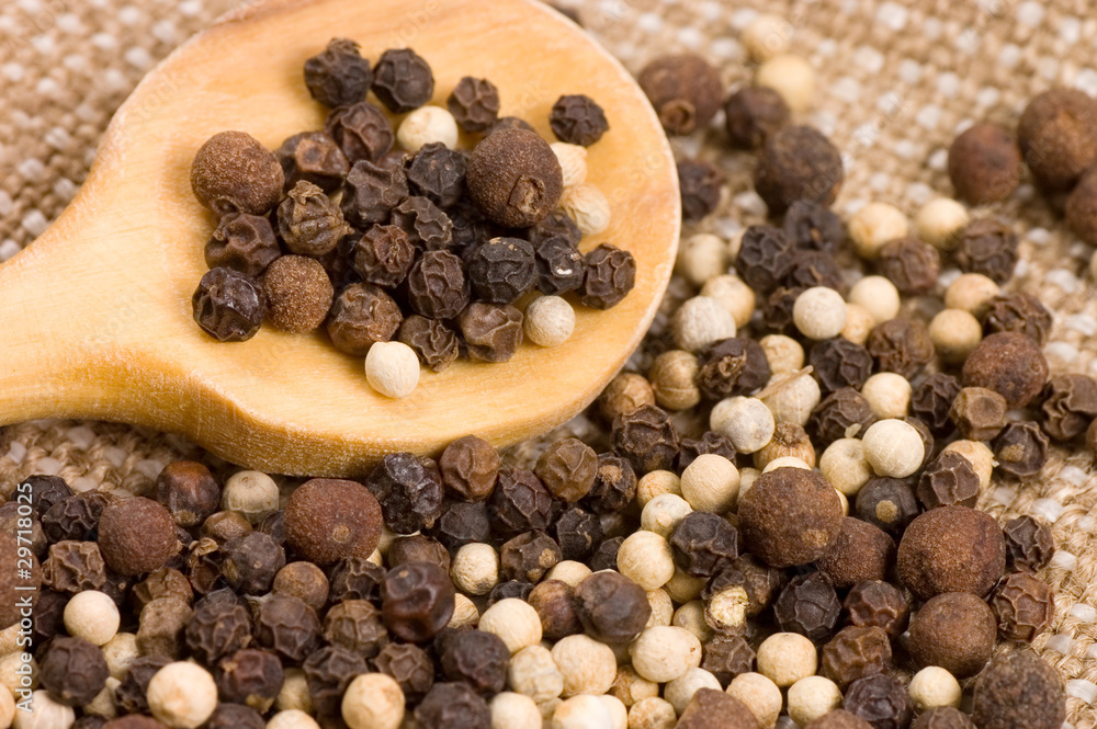 Black and white Peppercorns on a wooden spoon Black and white Peppercorns on a wooden spoon