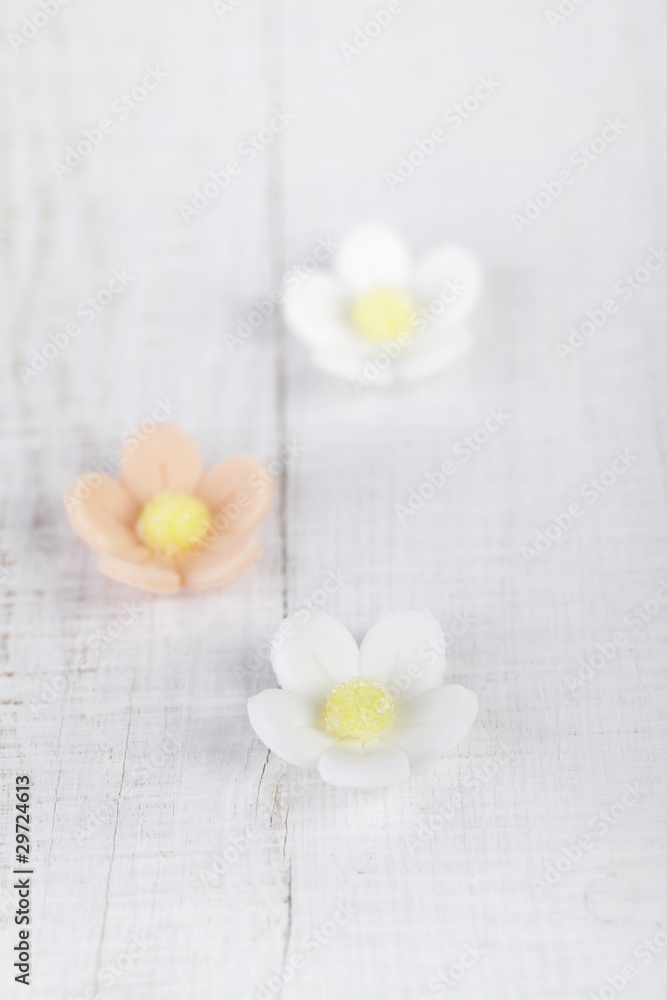 three sugar blossom flowers on white old table