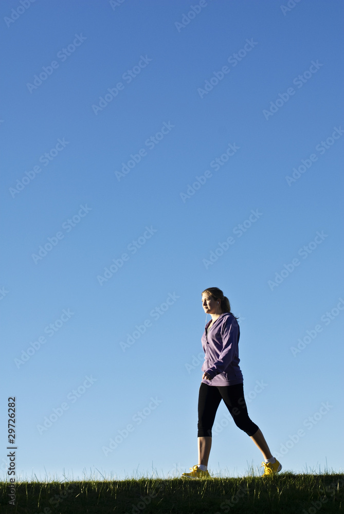 Fit woman walking while listening to music