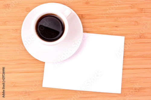 Coffee and blank paper on wooden surface