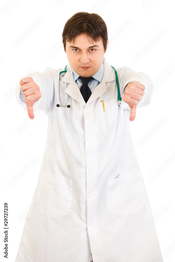 Serious young medical doctor pointing fingers down Serious young medical doctor pointing fingers down