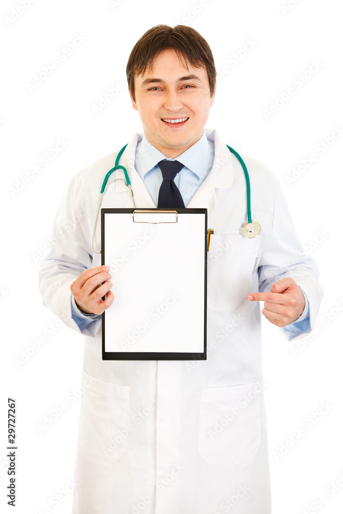 Smiling medical doctor pointing finger at blank clipboard Smiling medical doctor pointing finger at blank clipboard