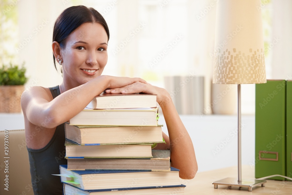 Girl posing with pile of books to learn Girl posing with pile of books to learn