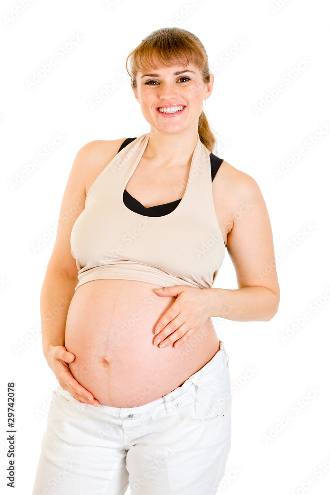 Smiling beautiful pregnant female holding her belly
