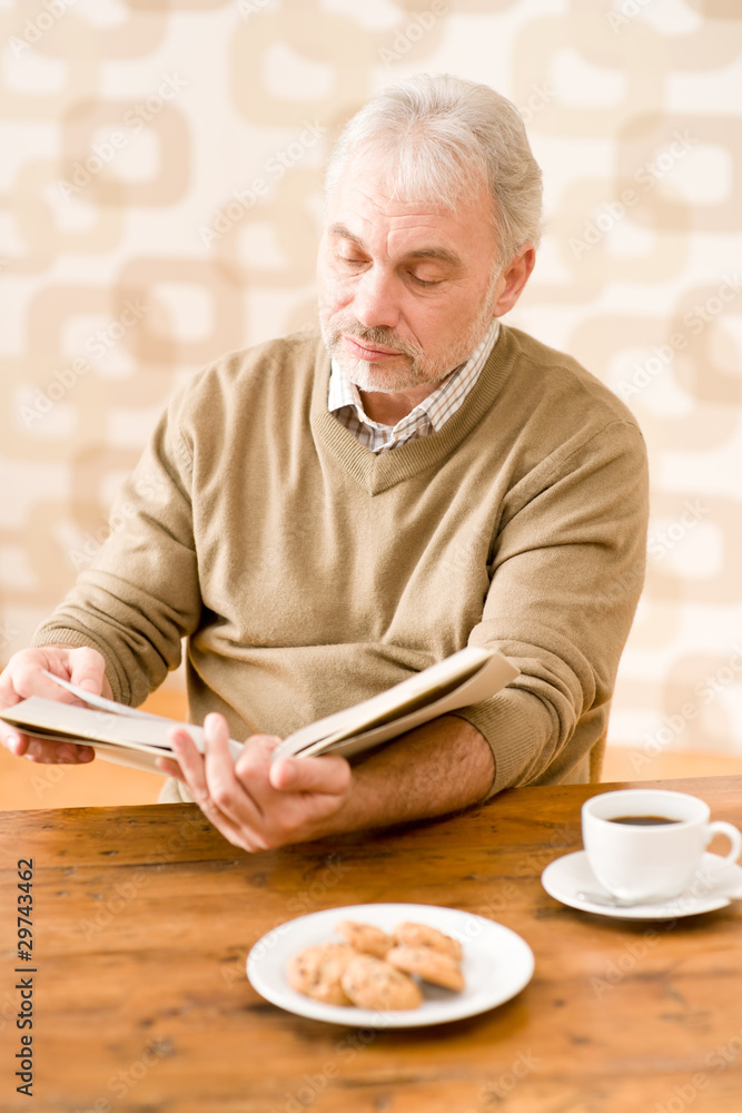 Senior mature man reading book having coffee Senior mature man reading book having coffee