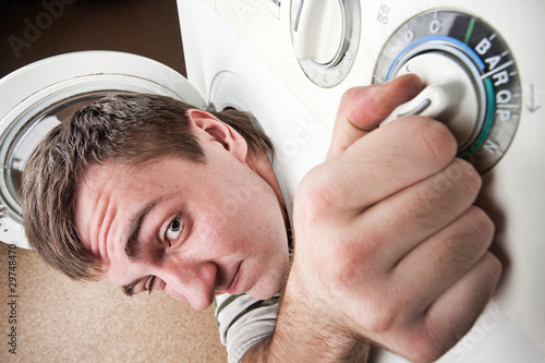 Surprised man inside washing machine photo