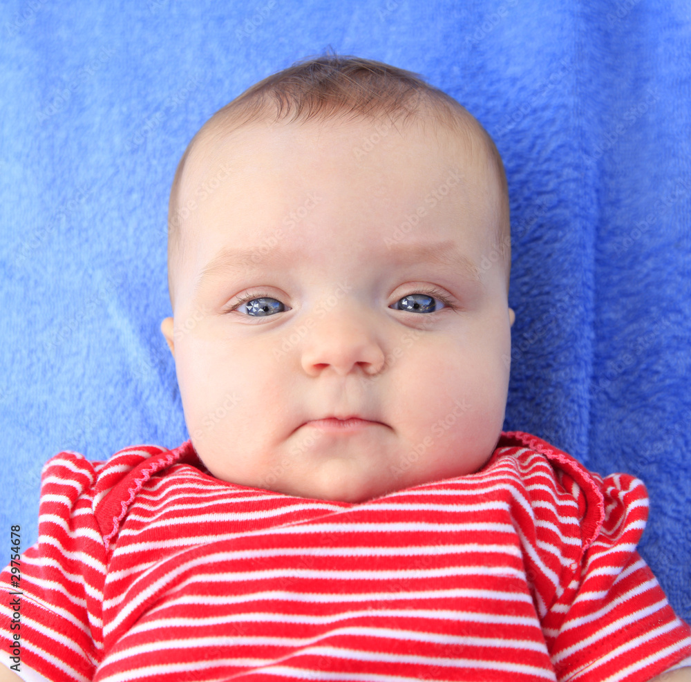 Baby girl portrait laying on a blue towel Baby girl portrait laying on a blue towel