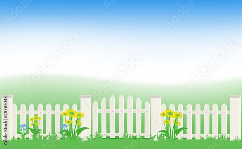 Grass and fence under blue sky.