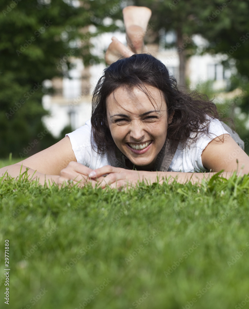 jeune femme rayonnante couchée dans l'herbe jeune femme rayonnante couchée dans l'herbe