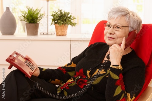 Pensioner woman using landline phone