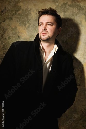 Man in black on a sharpened wall background © Demian