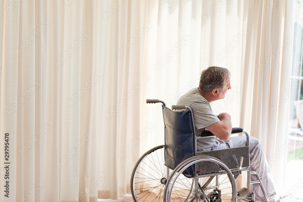 Man in his wheelchair looking out the window