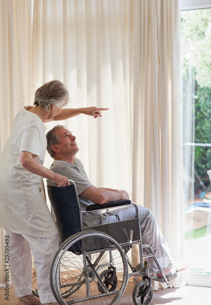 Retired couple looking out the window Retired couple looking out the window