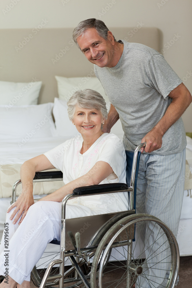 Retired woman in her wheelchair with her husband Retired woman in her wheelchair with her husband