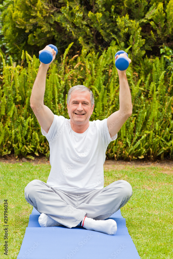 Retired man doing his exercises in the garden Retired man doing his exercises in the garden