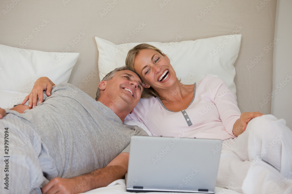 Lovely couple looking at their laptop Lovely couple looking at their laptop