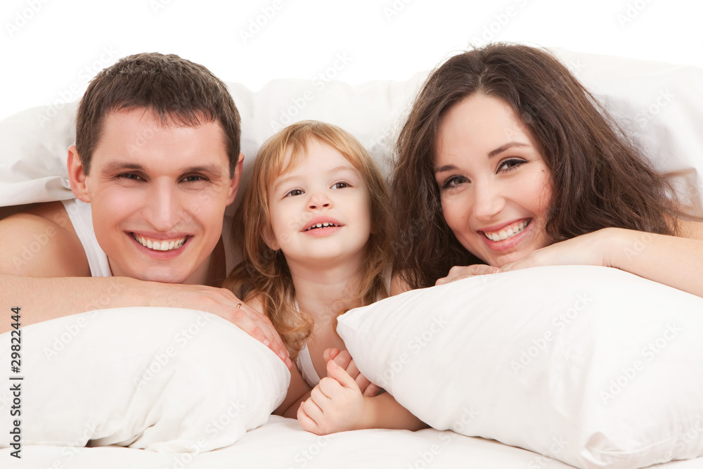 Happy family, mother, father and daughter resting on the white b Happy family, mother, father and daughter resting on the white b