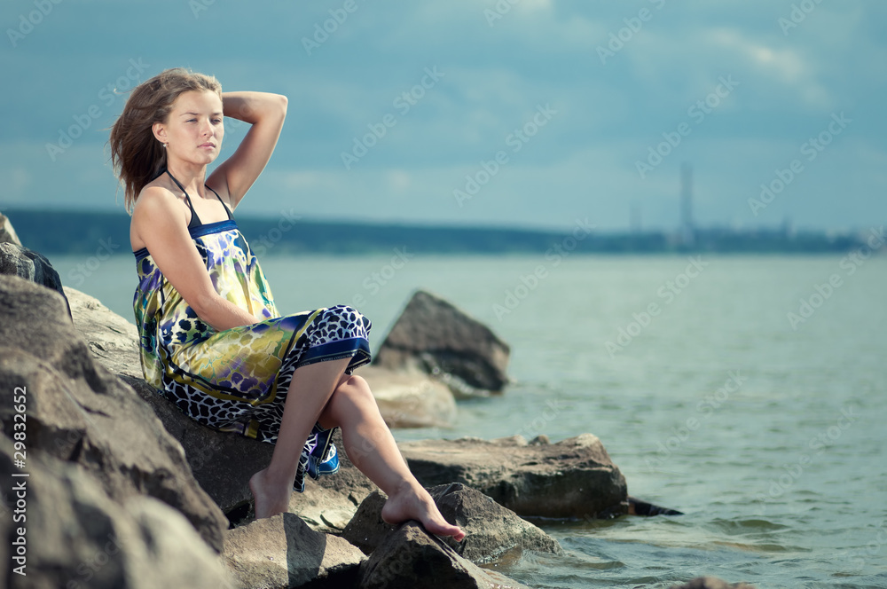 sad woman in dress sitting on rock sad woman in dress sitting on rock