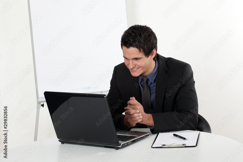 Junger Mann erfolgreich lachend am Laptop Junger Mann erfolgreich lachend am Laptop