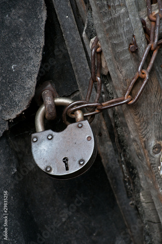 metal padlock on a door with a chain