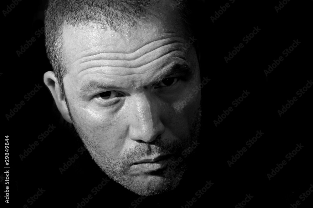 Low key portrait of menacing looking caucasian man Low key portrait of menacing looking caucasian man