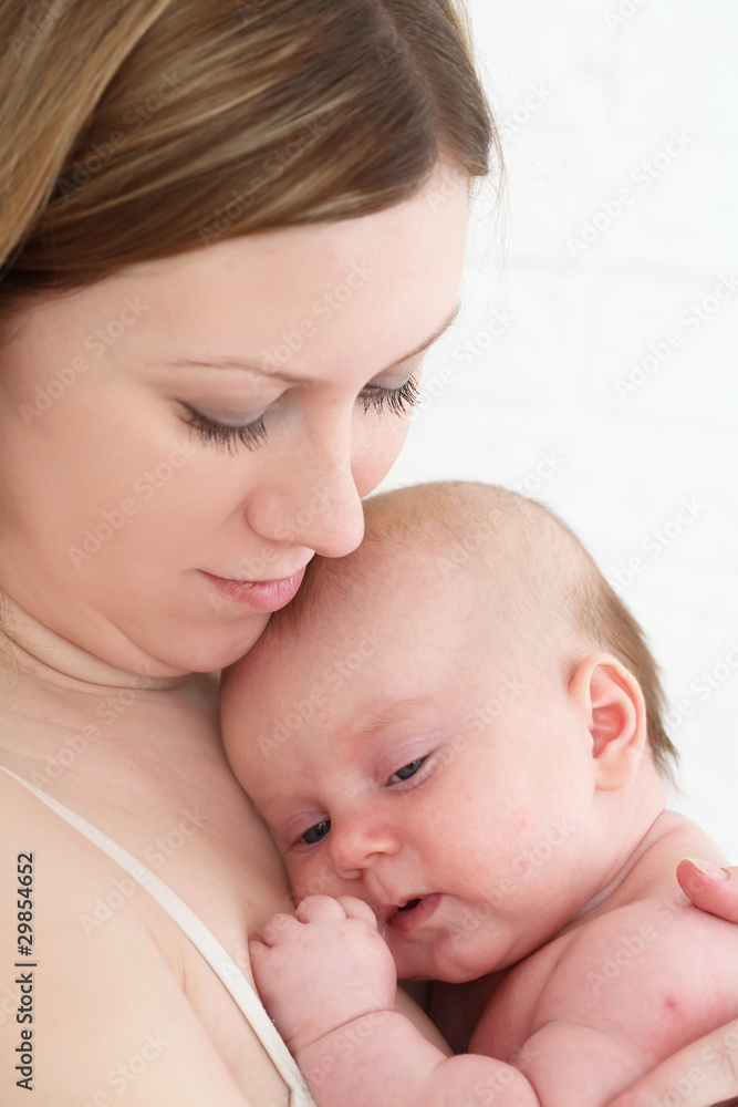 Young mum holds on hands of the chest baby Young mum holds on hands of the chest baby