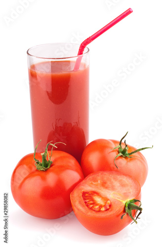 Full glass of fresh tomato juice with straw and tomatoes
