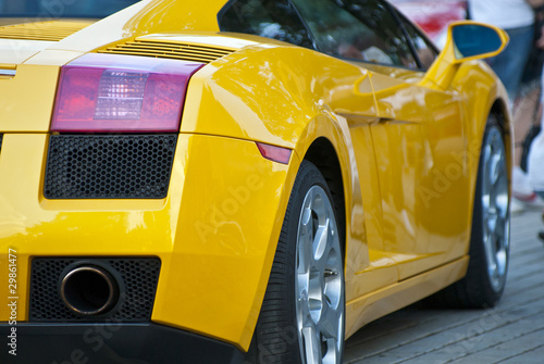 Yellow sportcar, half, back, on road