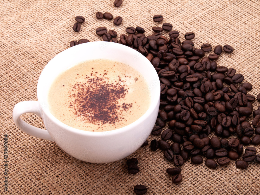 Fototapeta premium Coffee beans with cup on canvas