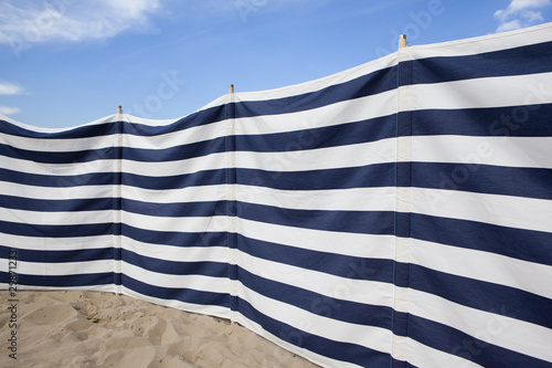blue and white striped windbreak at the beach photo