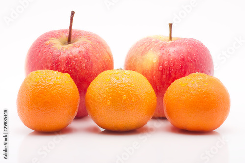 rote Äpfel und Mandarinen mit Tropfen vor weissem Hintergrund