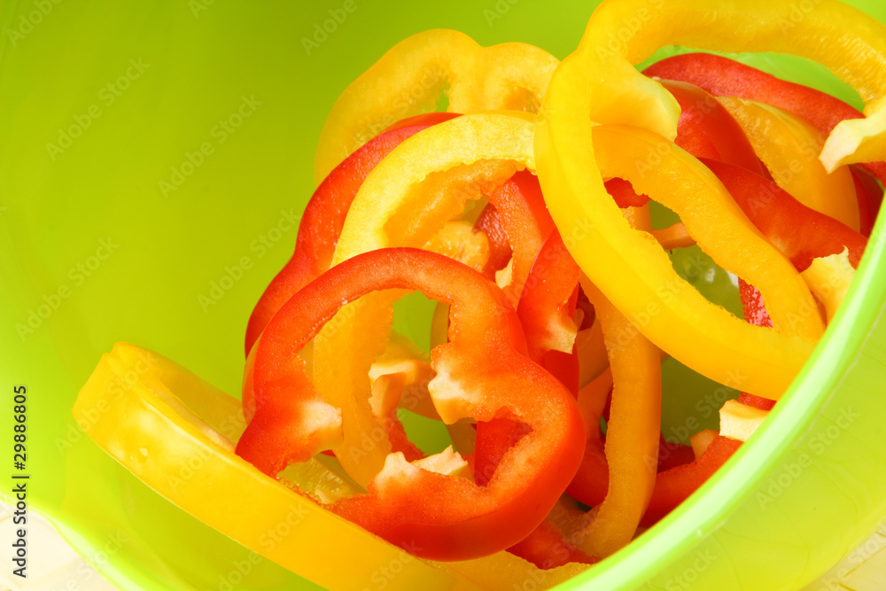 Sliced sweet peppers on bright green background Sliced sweet peppers on bright green background